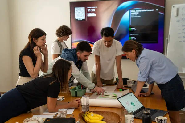Equipe colaborando em torno de uma mesa de projeto